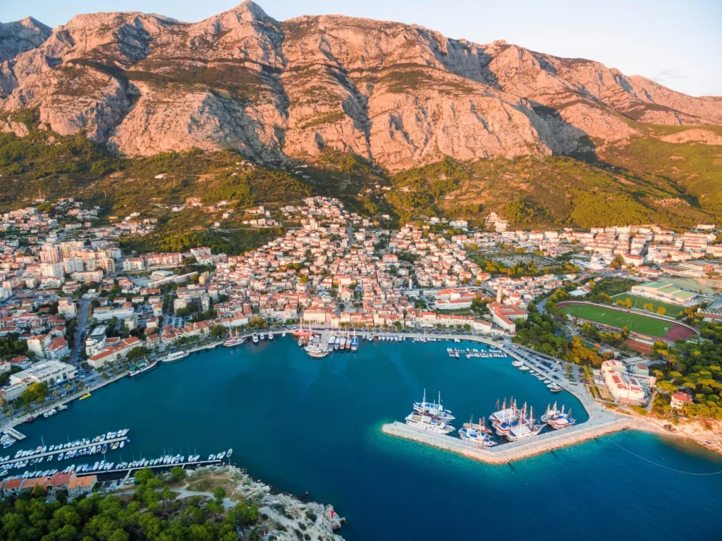 Aerial view on Makarska and marina at sunset with Biokovo mountain in background (Croatia).