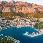 Aerial view on Makarska and marina at sunset with Biokovo mountain in background (Croatia).