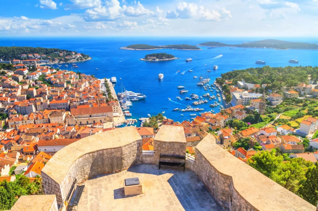 Sommerlandschaft an der Küste - Blick von der Festung auf den Stadthafen und den Yachthafen der Stadt Hvar auf der Insel Hvar an der kroatischen Adriaküste