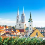 Croatian capital Zagreb, city skyline, catholic cathedral and red roofs in city center, view from Upper town. Christmas advent decoration.